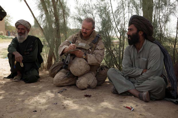 A civil affairs specialist with Regimental Combat Team 3 interacts with village elders during a patrol in Helmand Province on August 18, 2009. (Marine Corps photo)