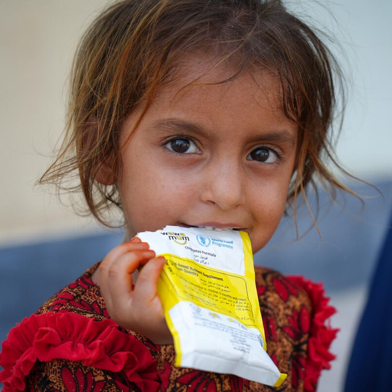 An Afghan girl eats a nutrition supplement distributed by the World Food Programme. (WFP in Afghanistan)