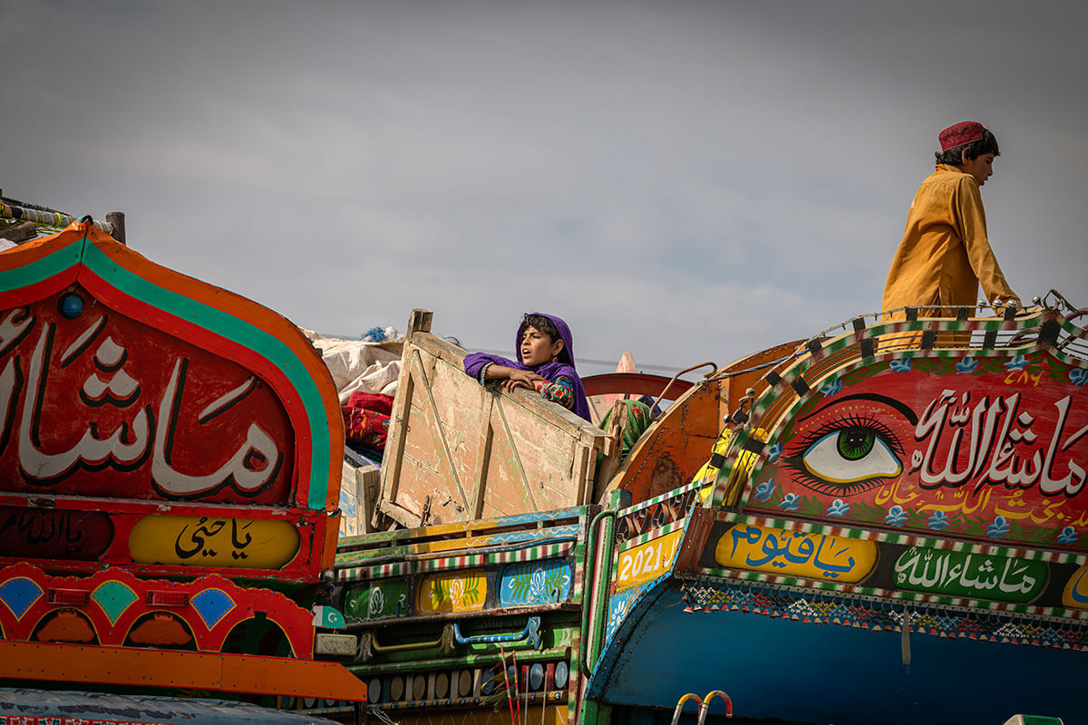 An Afghan girl waits for her family to receive assistance at the Spin Boldak border crossing, March 2024. (Photo by IOM/Mohammad Osman Azizi)